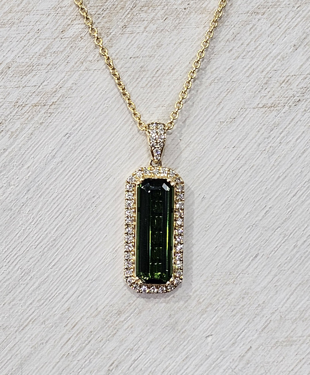 14k Yellow Gold chrome tourmaline pendant features a center stone of 5.09 carats with diamonds surrounding the center stone with a TCW of 5.45.
